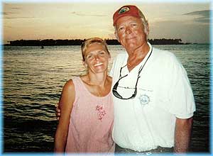 A man and woman standing next to each other near the water.